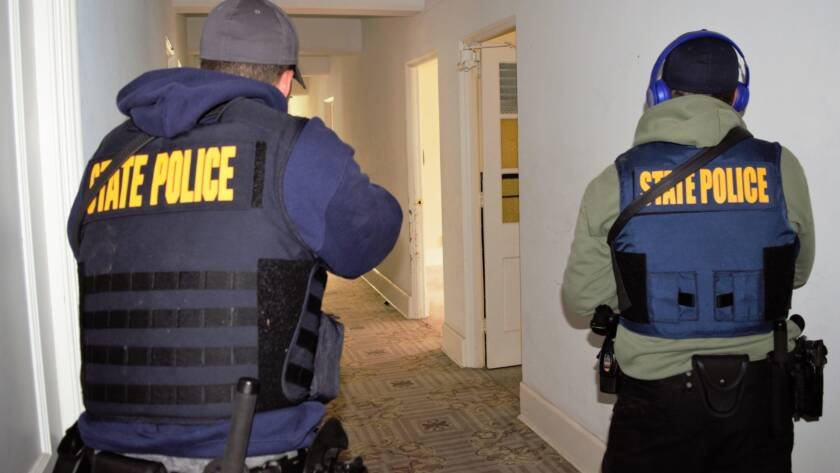 Officers clearing a building with a K9